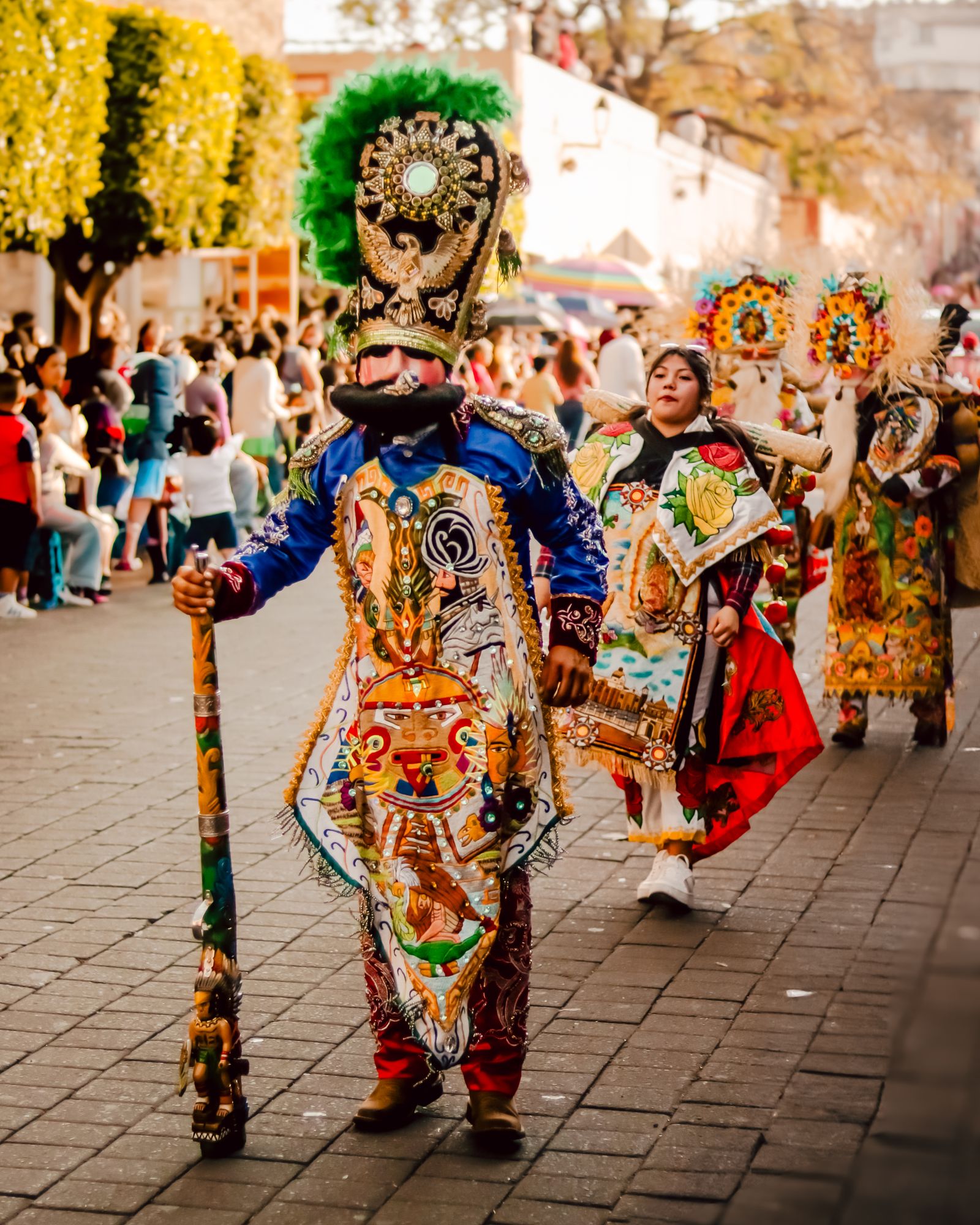 Families watching a colorful costumed parade